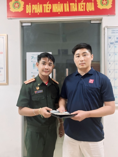 Đại úy Nguyễn Trung Phú - Phó Đội trưởng Phòng An ninh kinh tế Công an tỉnh Lai Châu (bên phải) trao trả số tài sản cho lưu học sinh Lào Phongsavath Souksavanh