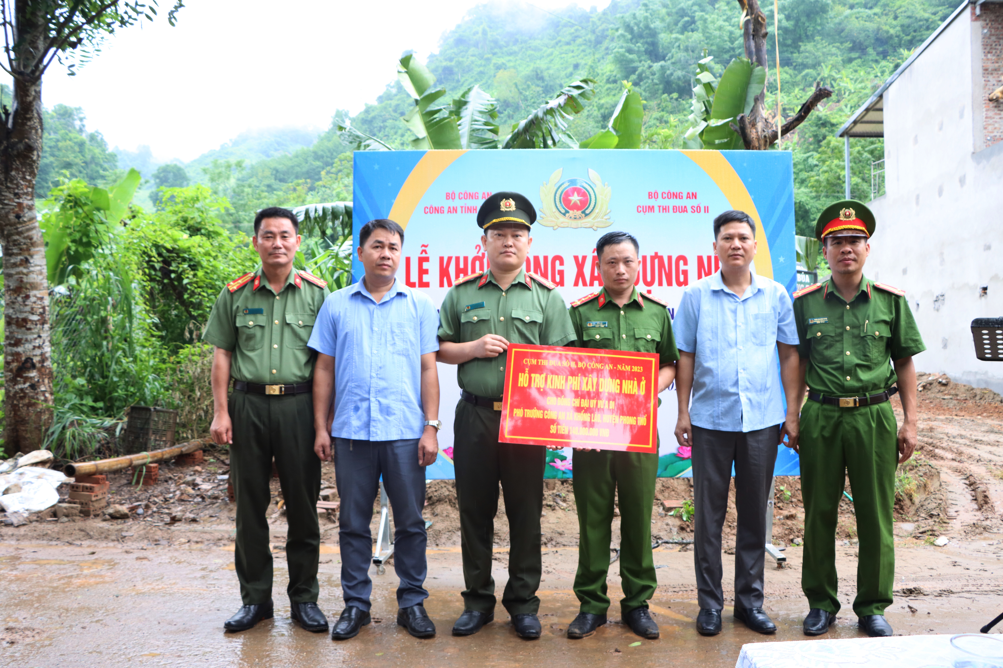 Các đồng chí lãnh đạo trao kinh phí hỗ trợ xây dựng nhà cho Đại úy Vừ A Di - Phó trưởng Công an xã Khổng Lào, Công an huyện Phong Thổ