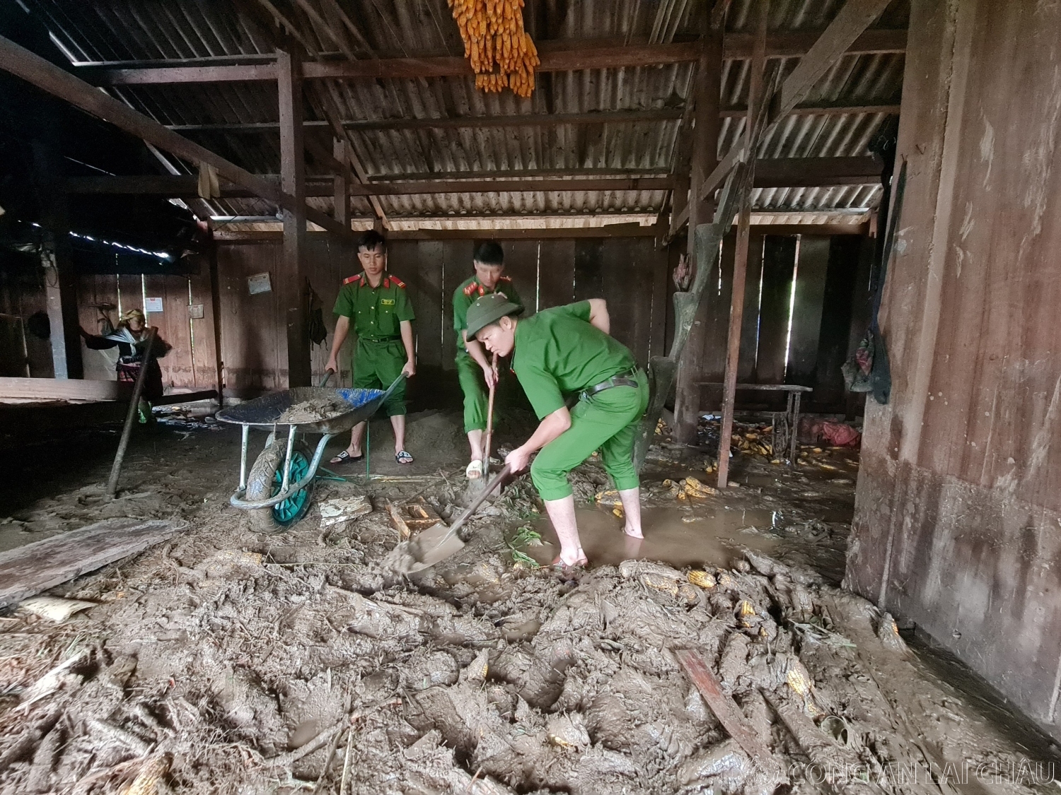 Công an huyện Than Uyên giúp dân xúc bỏ bùn đất tràn vào nhà tại bản Hô Ta, xã Tà Mung