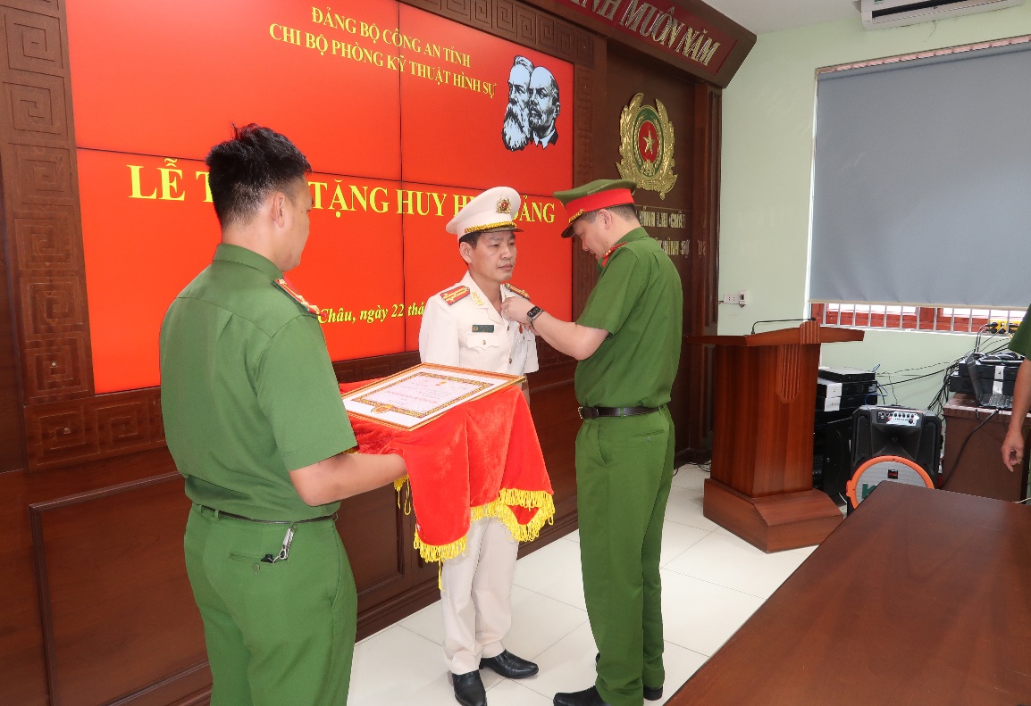 Đồng chí Phạm Hải Đăng, Ủy viên Ban thường vụ Đảng ủy, Phó Giám đốc Công an tỉnh trao Huy hiệu 30 năm tuổi Đảng cho đồng chí Hoàng Văn Châu