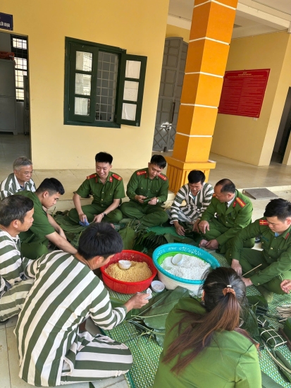 Đồng chí Sùng A Sài Trưởng phân trại tạm giam hướng dẫn cho can phạm nhân gói bánh chưng