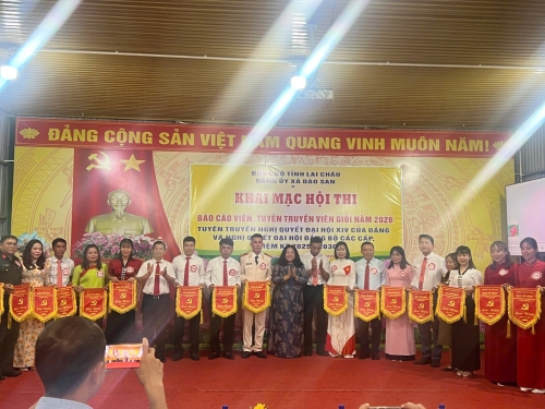 Đồng chí Bí thư Đảng ủy, Chủ tịch HĐND xã trao cờ lưu niệm cho các thi sinh dự thi.