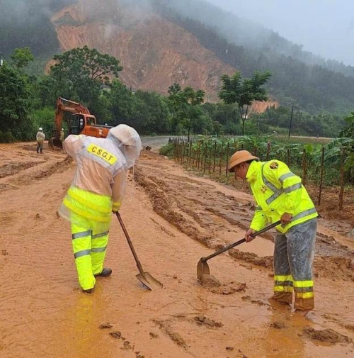 Lực lượng CSGT tham gia hỗ trợ dọn bùn đất ngập đường do mưa, lũ