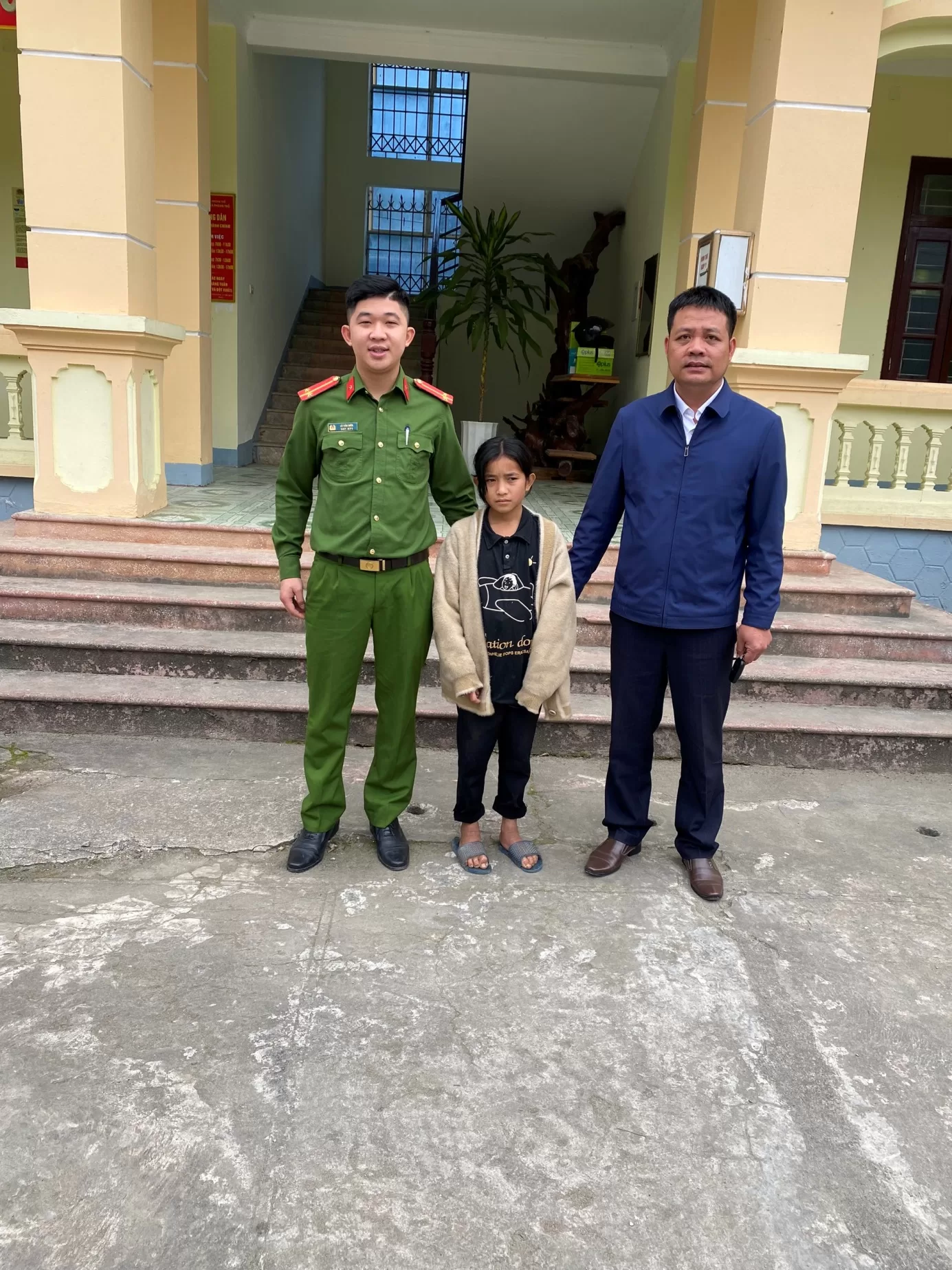 Cán bộ Công an thị trấn Phong Thổ bàn giao cháu bé cho Thầy giáo Vũ Văn Sơn, Hiệu trưởng Trường Phổ thông dân tộc bán trú THCS xã Nậm Xe