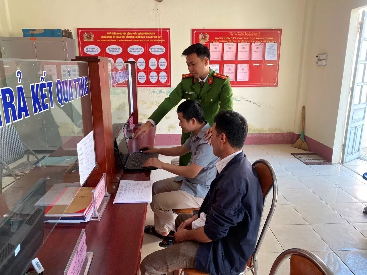 Cán bộ Công an xã Mường Than hướng dẫn Công dân thao tác trên máy vi tính làm thủ tục đăng ký cư trú trên Cổng thông tin dịch vụ công