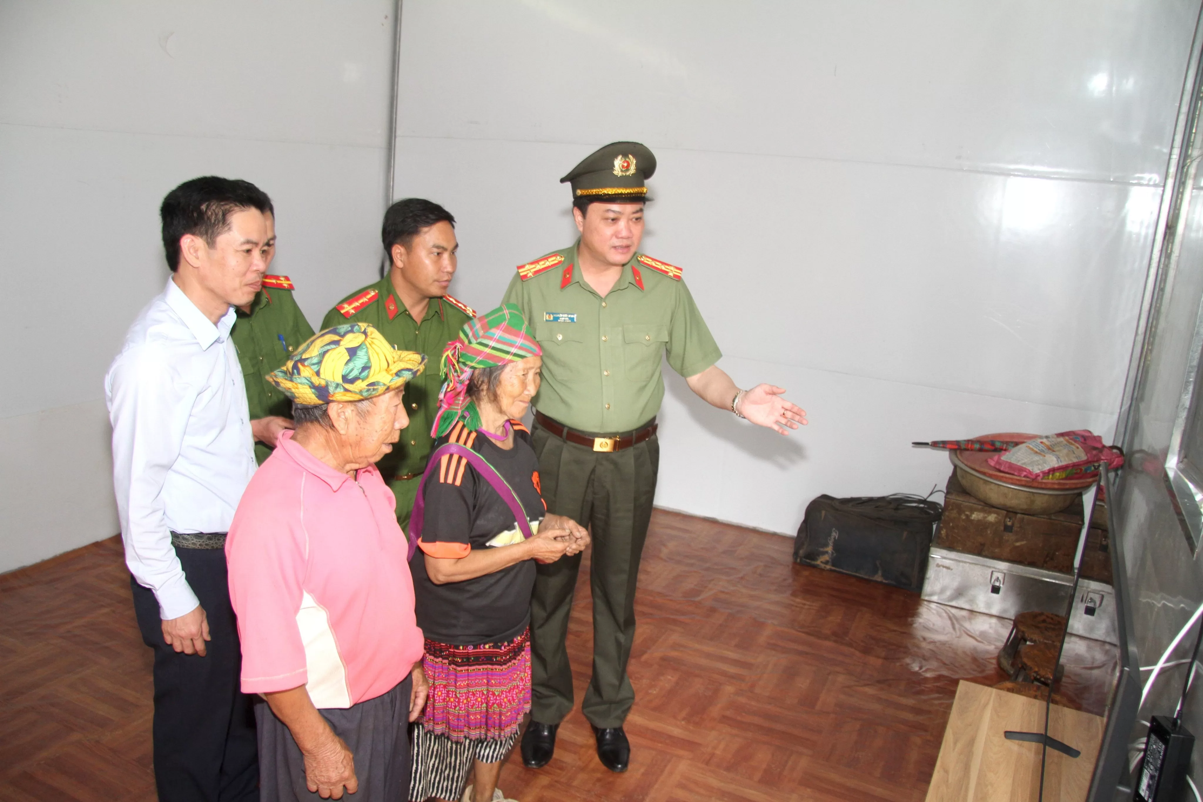 Đại diên Ban giám đốc Công an tỉnh và chính quyền địa phương hướng dẫn gia đình cụ ông cụ bà sử dụng tivi (1)