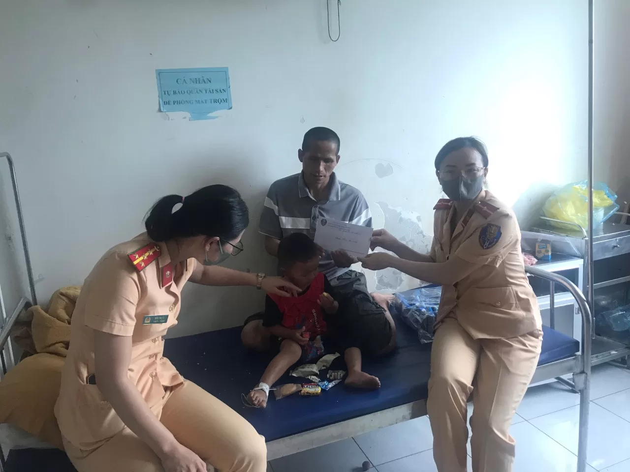 Chi Đoàn và Hội phụ nữ Phòng Cảnh sát giao thông  tặng quà cho bem Thắng và người Bác đang nuôi dưỡng em