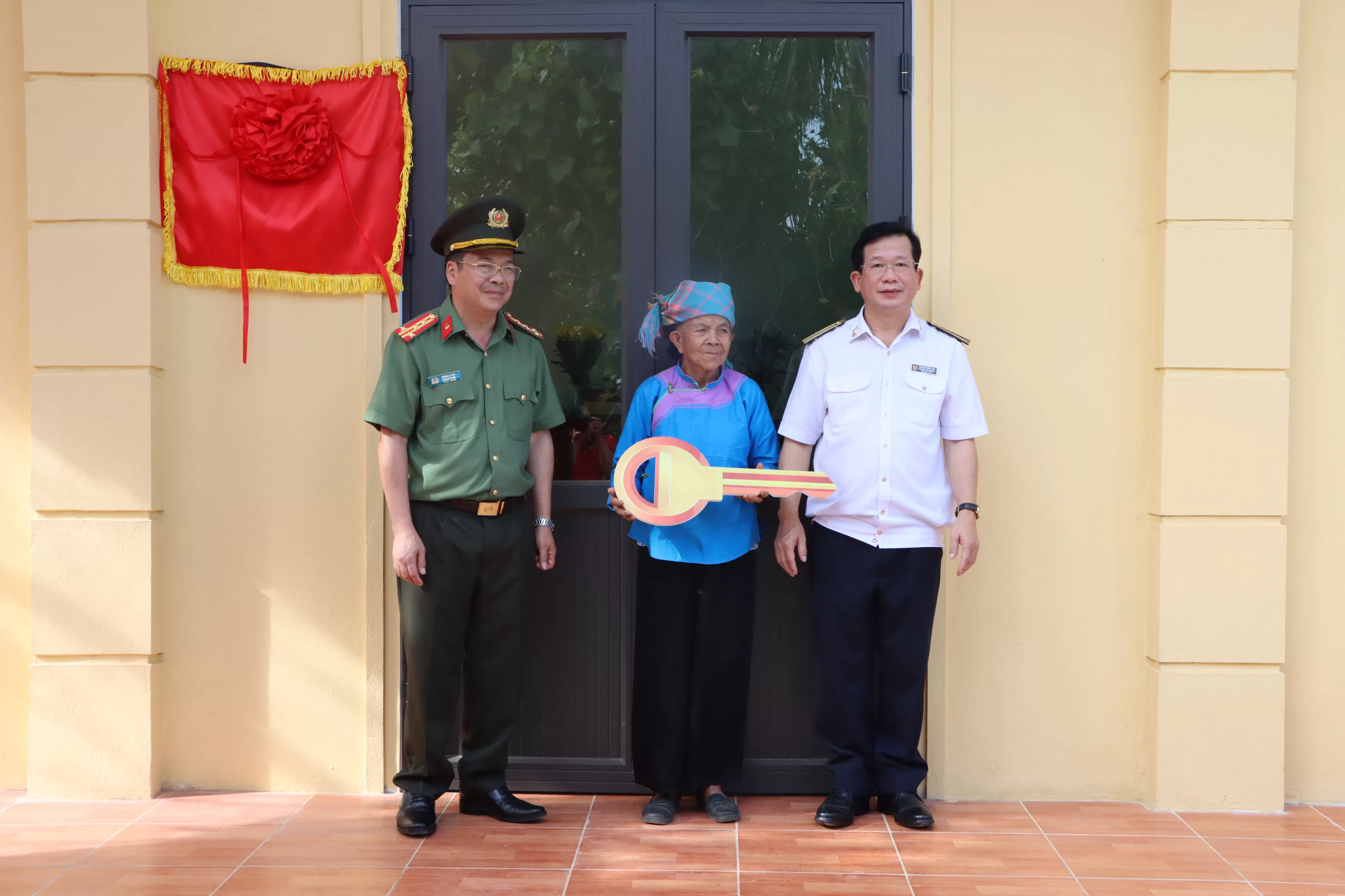 Đại diện lãnh đạo hai đơn vị trao chìa khóa nhà tượng trưng cho bà Tống Thị Din, là vợ Liệt sỹ Vàng Văn Siềng
