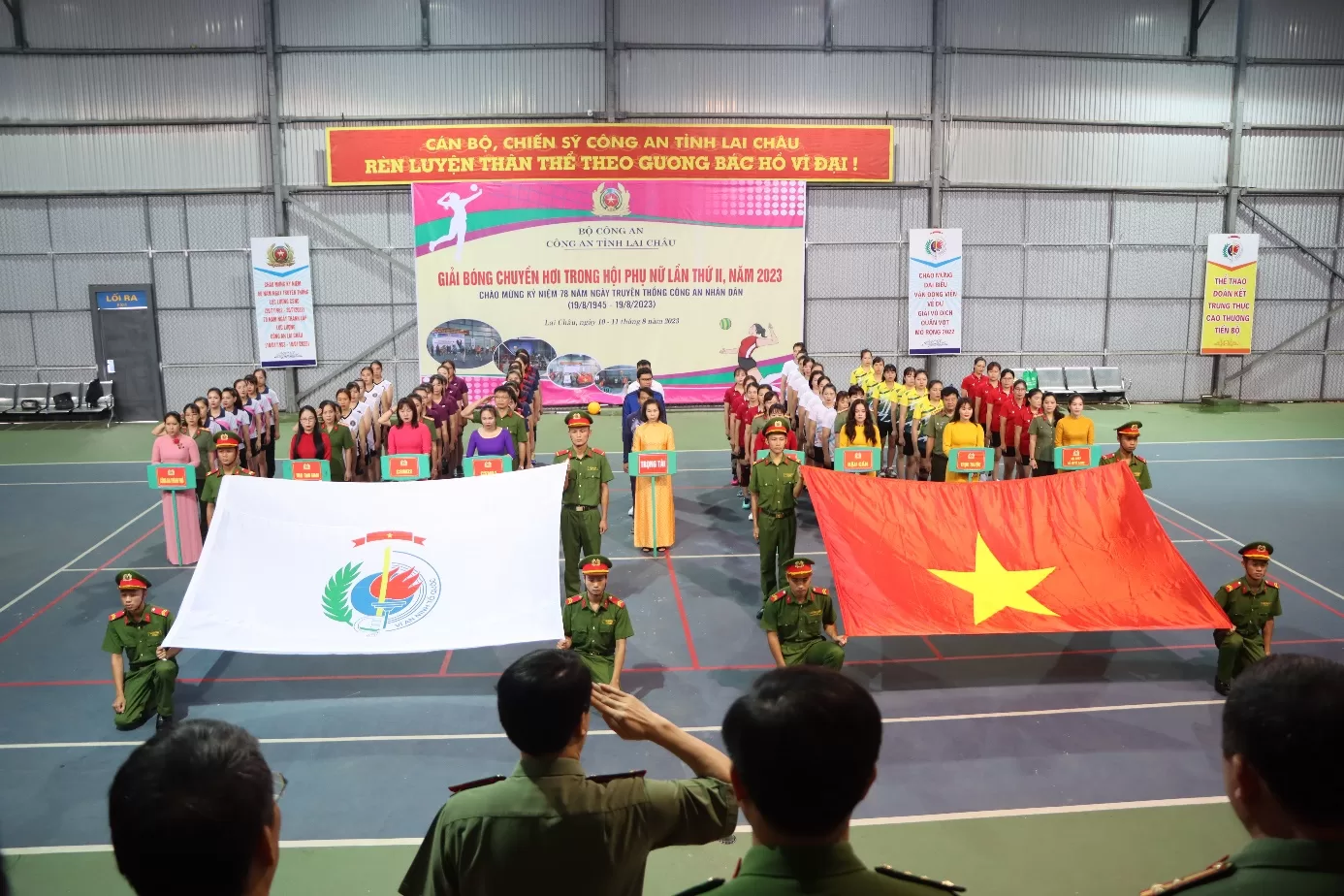 Các đại biểu, vận động viên và khán giả thực hiện nghi lễ chào cờ