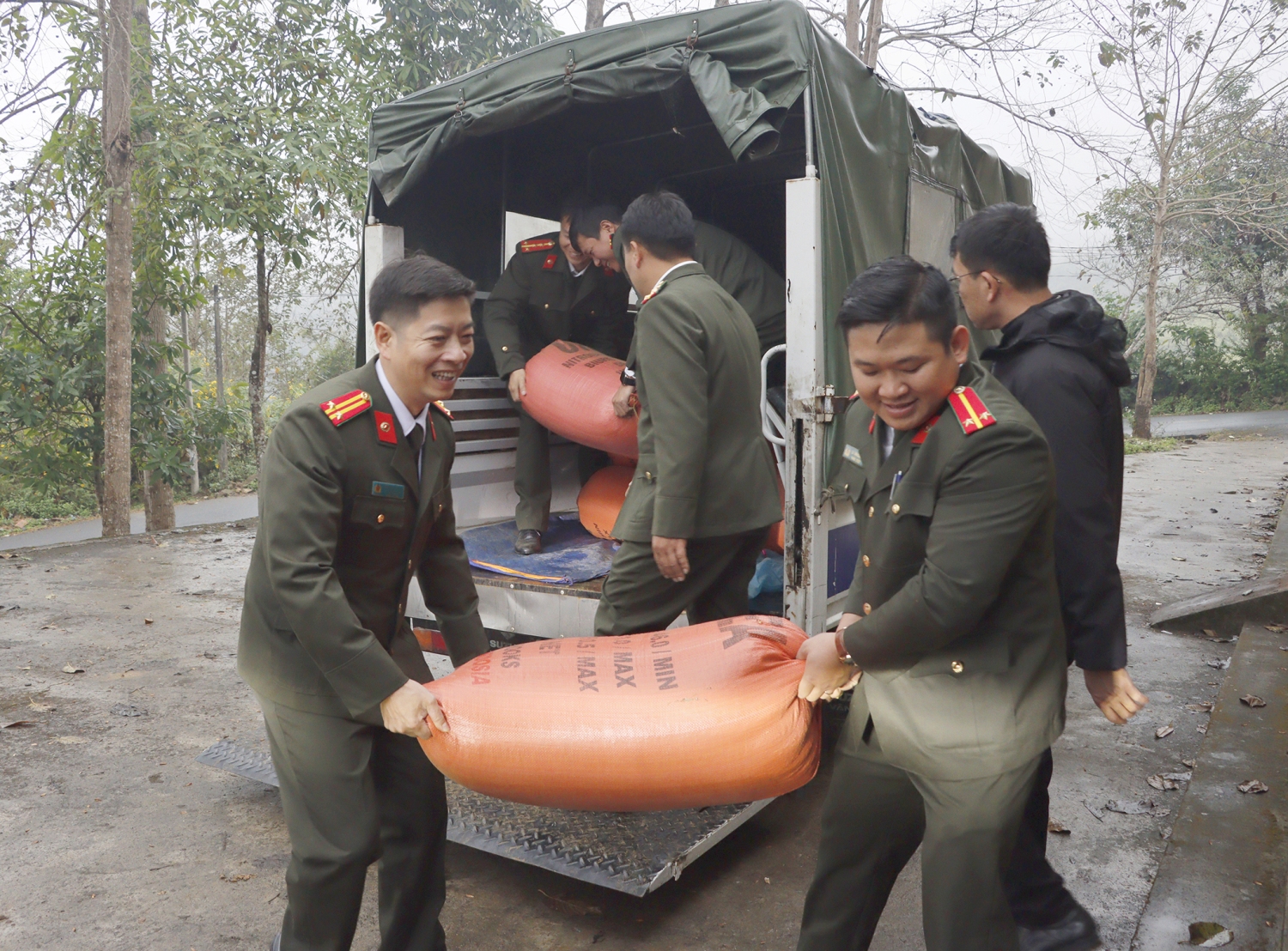 Cán bộ, chiến sỹ lực lượng An ninh nhân dân hỗ trợ gia đình anh Phừ di chuyển tài sản, đồ đạc chuẩn bị làm nhà mới