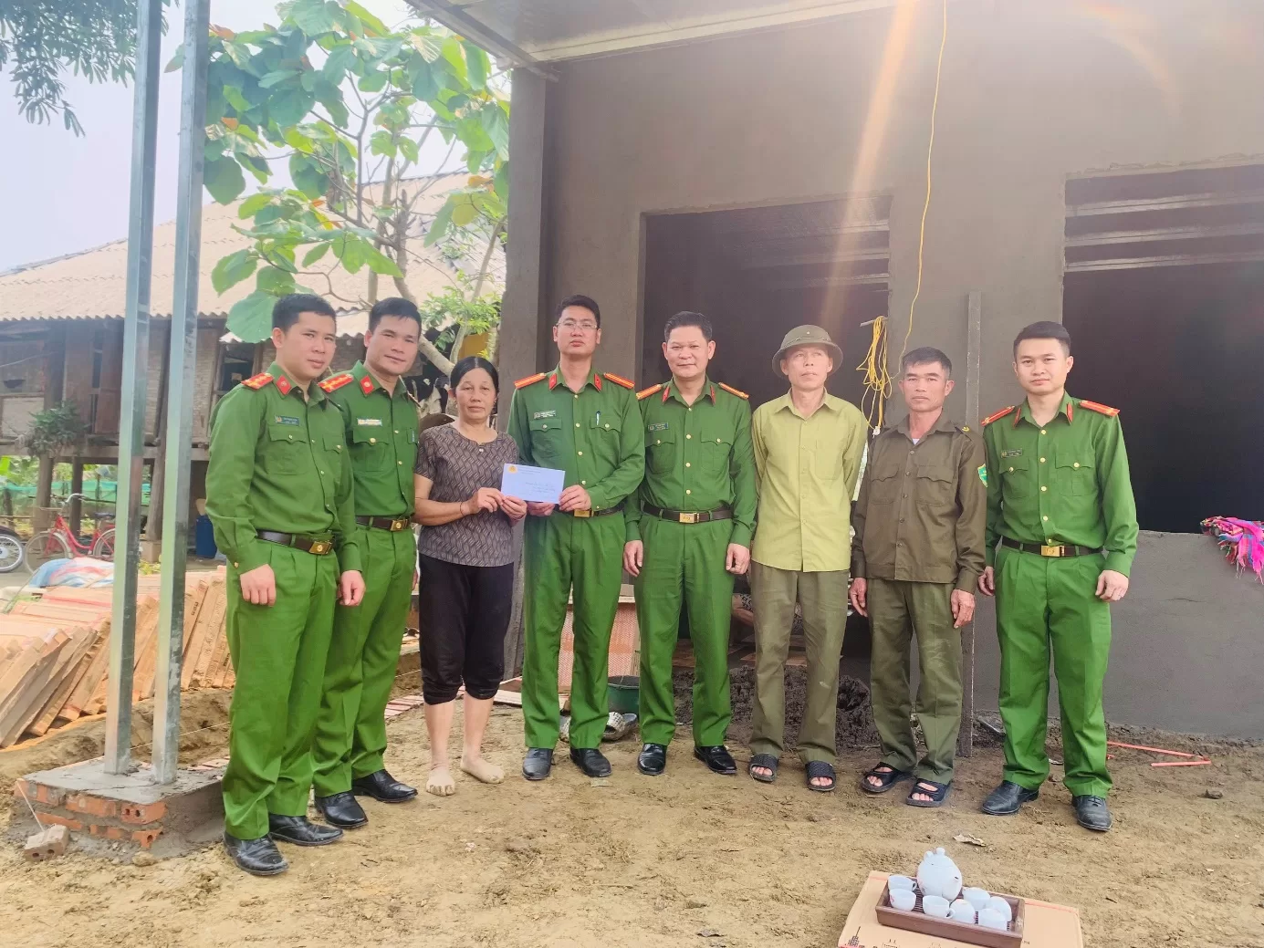 Công an xã Mường Than trao tiền và gạch lát nền cho bà Lò Thị Tý