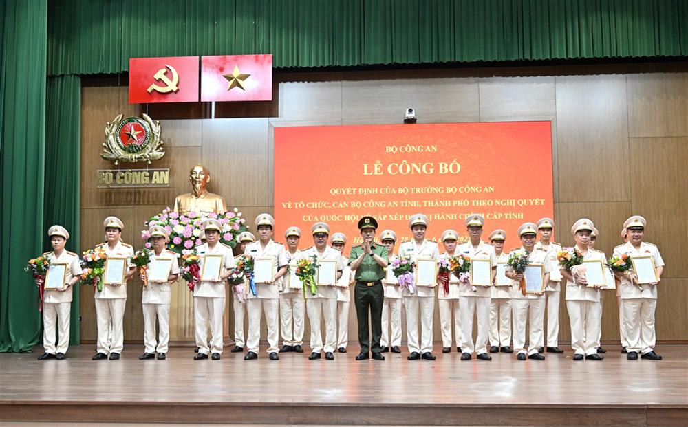 Bộ trưởng Lương Tam Quang trao Quyết định và tặng hoa chúc mừng 23 đồng chí Giám đốc Công an địa phương sau sáp nhập.