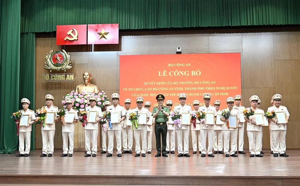 Bộ trưởng Lương Tam Quang trao Quyết định và tặng hoa chúc mừng 23 đồng chí Giám đốc Công an địa phương sau sáp nhập.