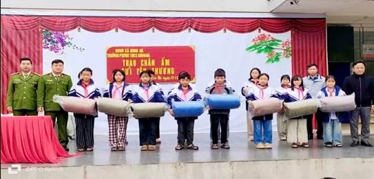 Cán bộ, lãnh đạo Công an xã Khun Há trao tặng chăn tại trường PTDTBT THCS Khun Há