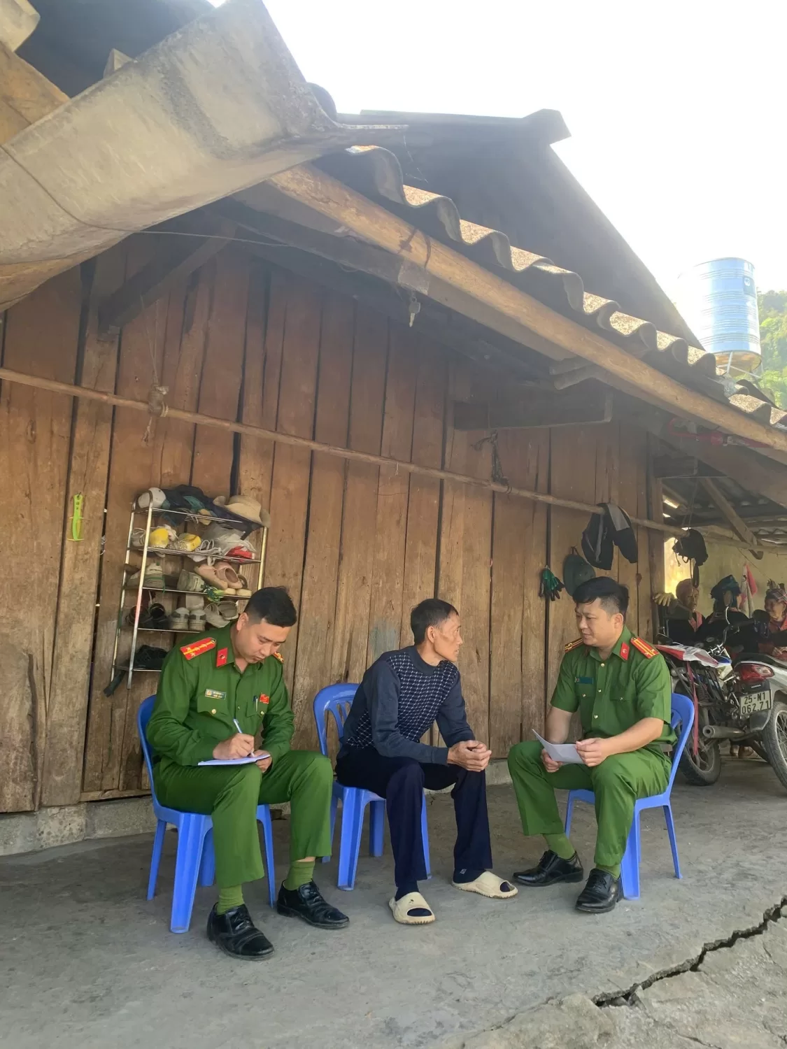 Cảnh Công an xã làm việc thăm hỏi tại nhà đối tượng thể hiện sự quan tâm, động viên họ tu chí làm ăn, lao động sản xuất