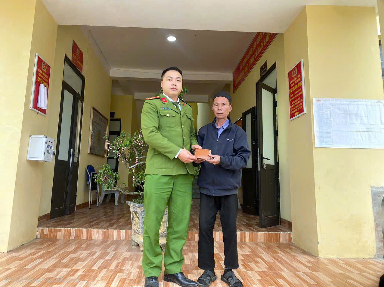 Cán bộ Công an xã Tả Lèng trao trả lại tài sản cho người dân.