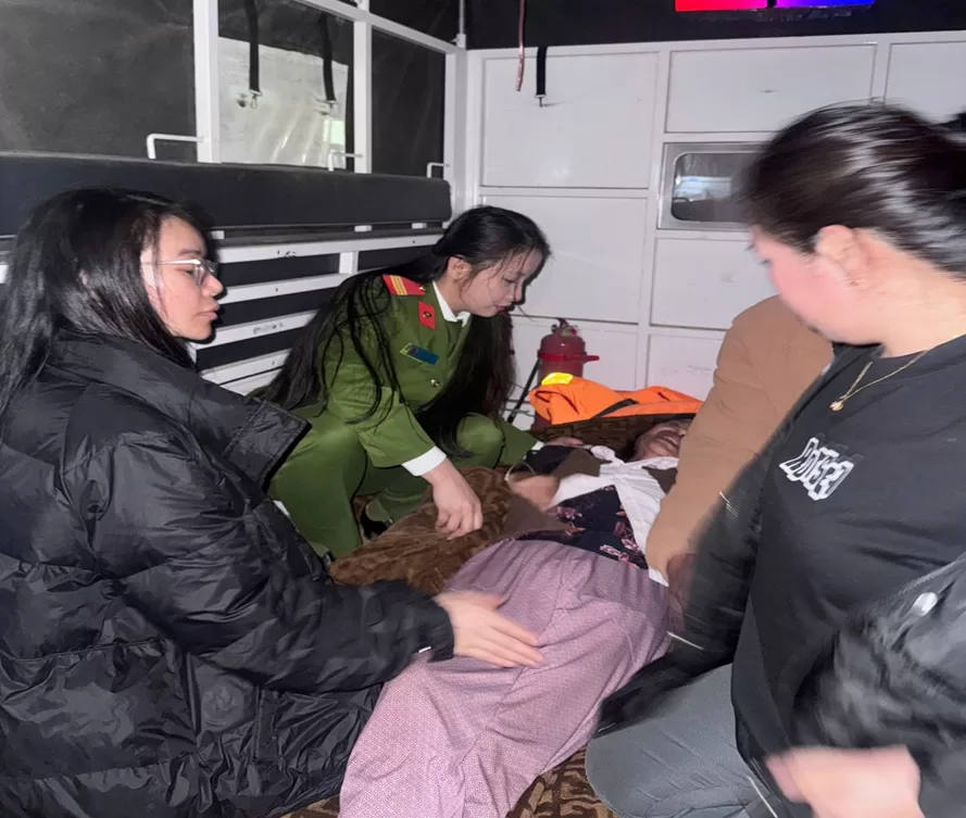 Cán bộ Công an xã cùng người nhà khẩn trương hỗ trợ đưa bệnh nhân lên xe đến Trung tâm y tế