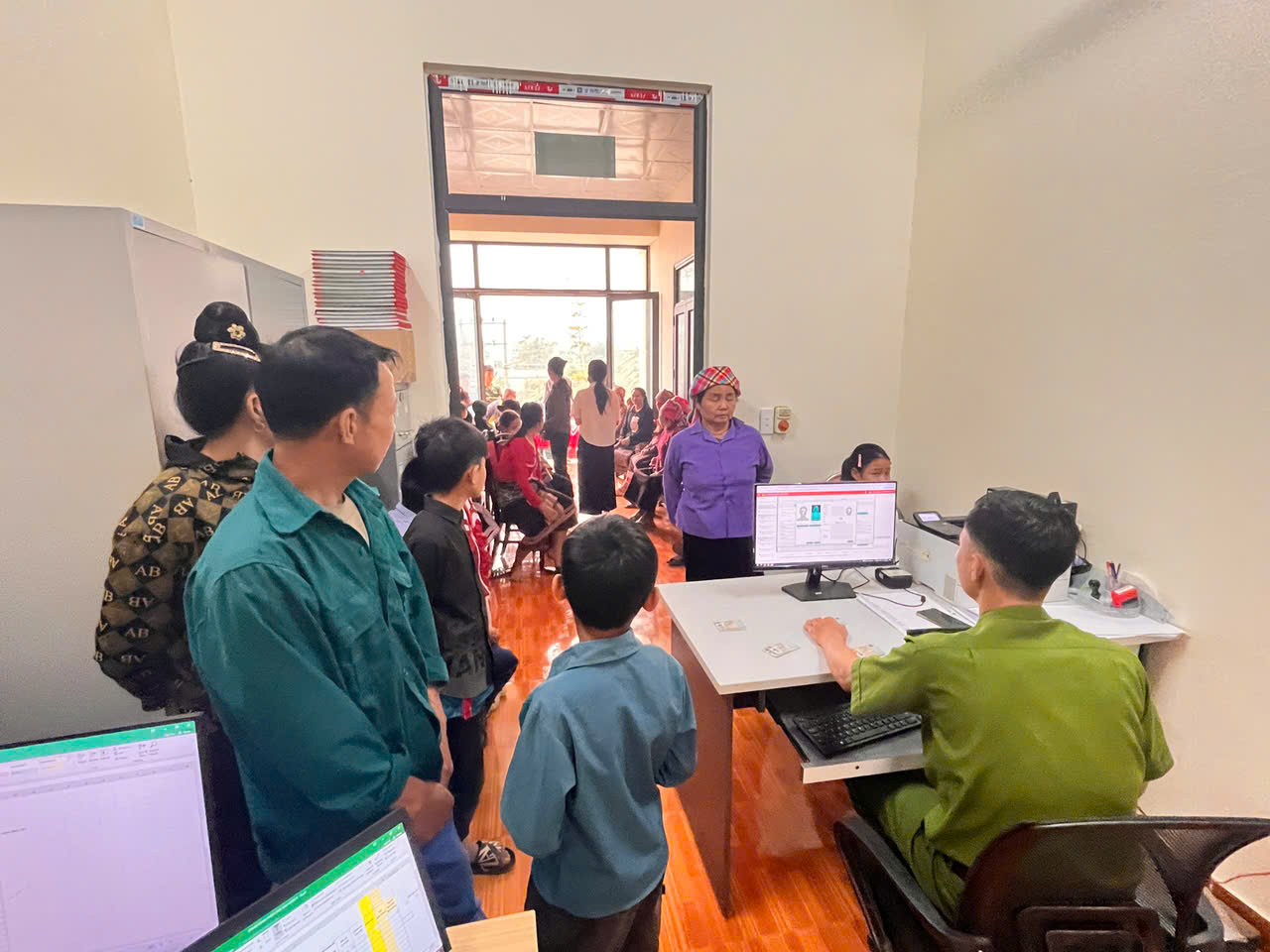 Cán bộ Công an xã hướng dẫn phụ huynh kê khai thông tin, hoàn thiện hồ sơ cấp căn cước, định danh điện tử cho trẻ em.