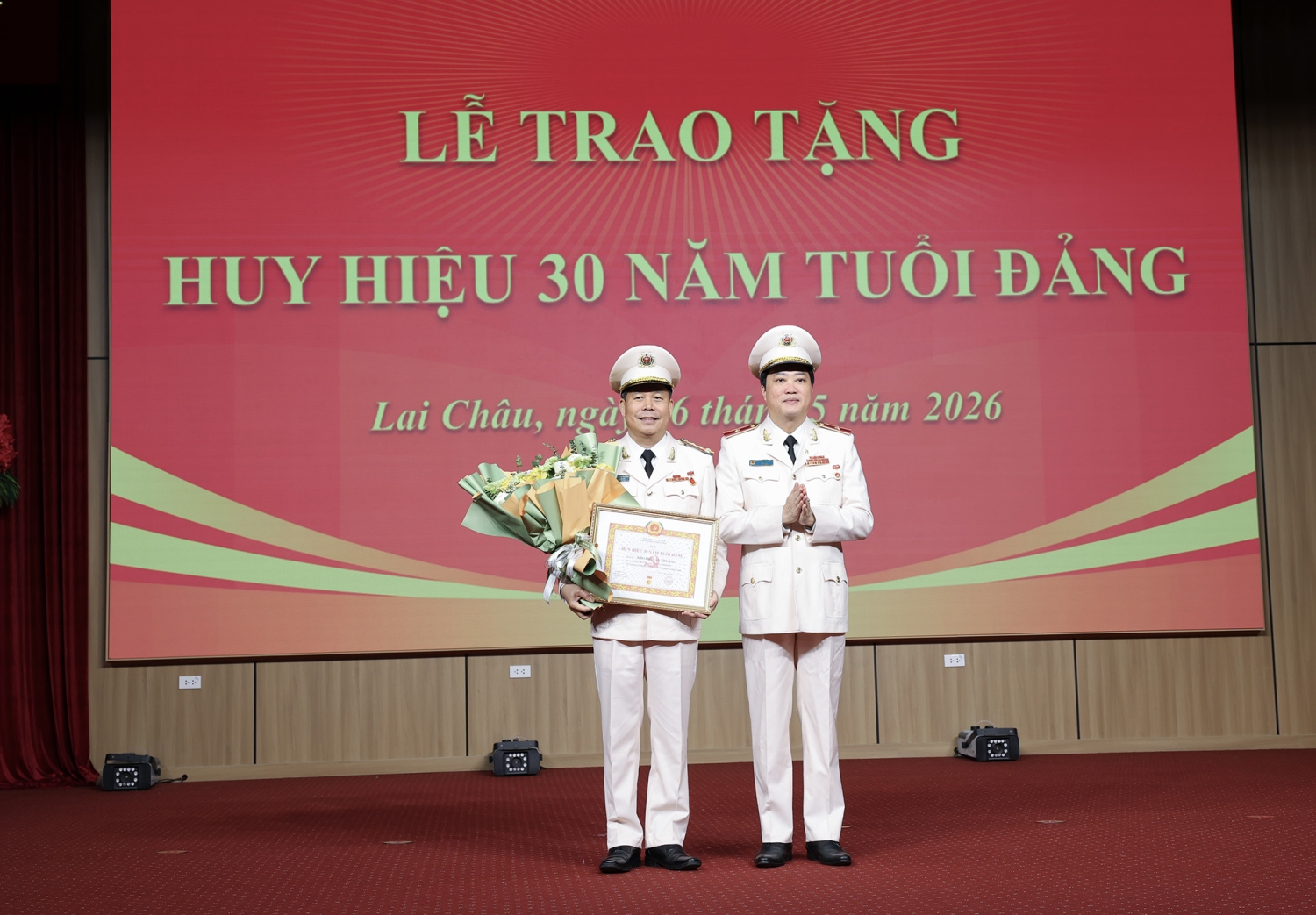Đồng chí Sùng A Hồ - Phó Bí thư Tỉnh ủy đã trao Huy hiệu 30 năm tuổi Đảng và tặng hoa chúc mừng đồng chí Thiếu tướng Nguyễn Viết Giang.