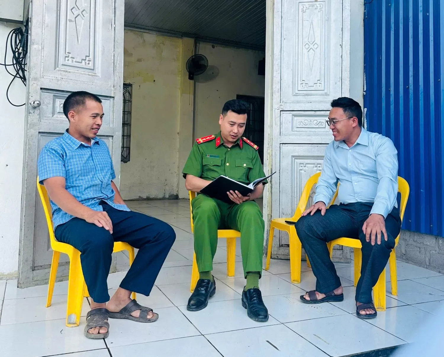 Đồng chí công an xã lắng nghe Bí thư chi bộ và Trưởng bản Chù Khèo báo cáo về tình hình ANTT tại địa bàn thời gian vừa qua