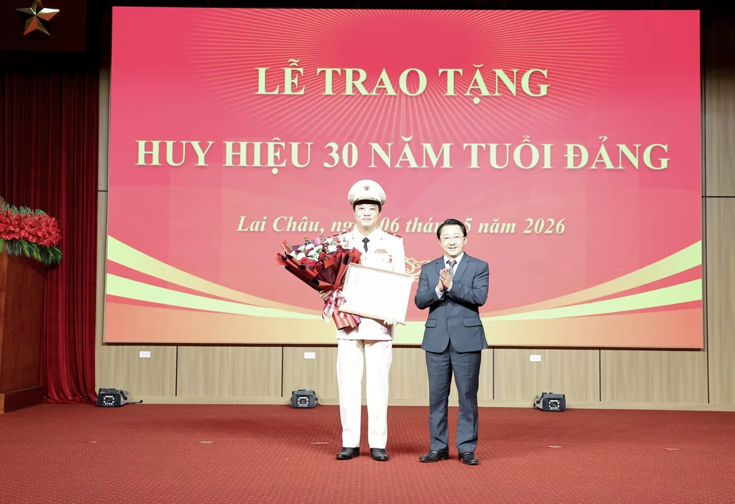 Đồng chí Sùng A Hồ - Phó Bí thư Tỉnh ủy đã trao Huy hiệu 30 năm tuổi Đảng và tặng hoa chúc mừng đồng chí Thiếu tướng Nguyễn Viết Giang.