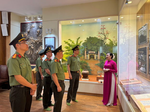 Đoàn Công tác nghe hướng dẫn viên giới thiệu vể các tư liệu và hiện vật lịch sử