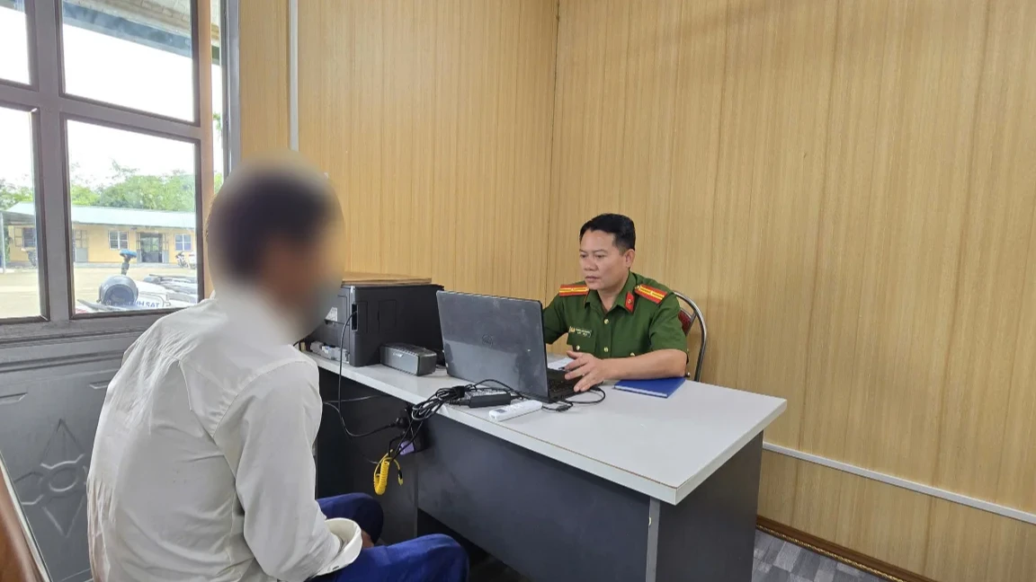 Cán bộ Công an xã hướng dẫn người tái hòa nhập cộng đồng làm thủ tục theo dõi, quản lý