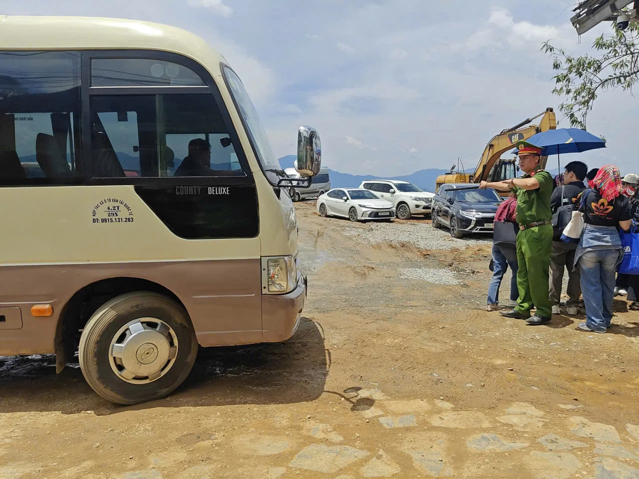 Lực lượng Công an xã phân luồng giao thông và hướng dẫn khu vực dừng đỗ cho đoàn xe chở ban tổ chức, thí sinh tại các khu vực đường hẹp dẫn vào bản