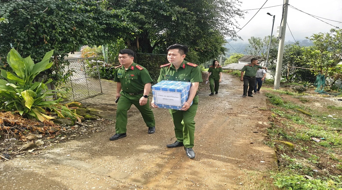Đại diện Công an xã Tả Lèng trao quà cho các hộ nghèo trên địa bàn.