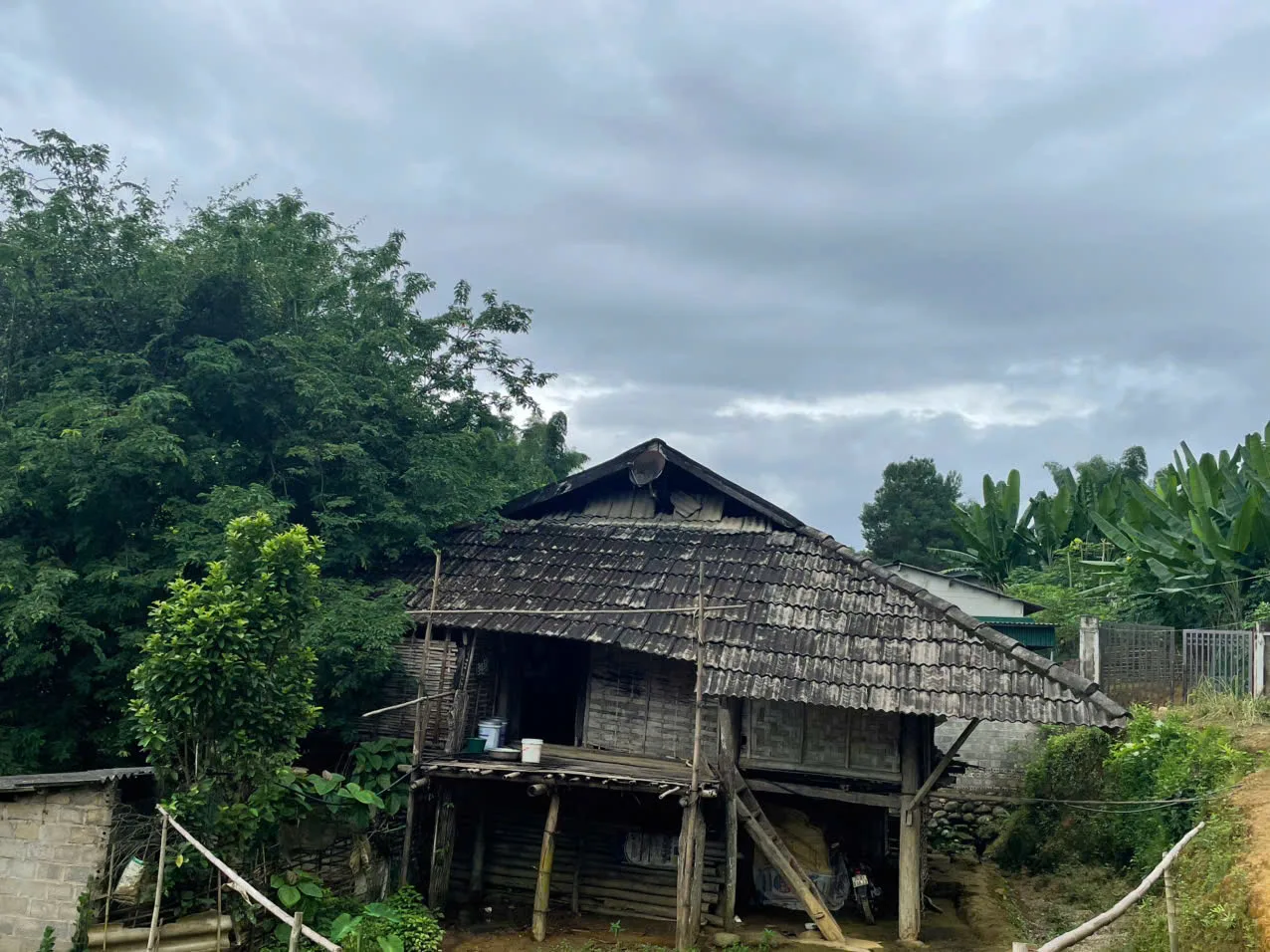 Ngôi nhà sản và hình ảnh cụ bà Tòng Thị Ổ vui vẻ khi có đoàn đến thăm.