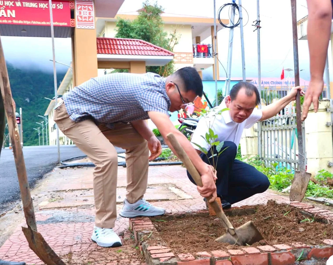 Đồng chí Lầu A Tình tham gia trồng cây xanh trên tuyến đường