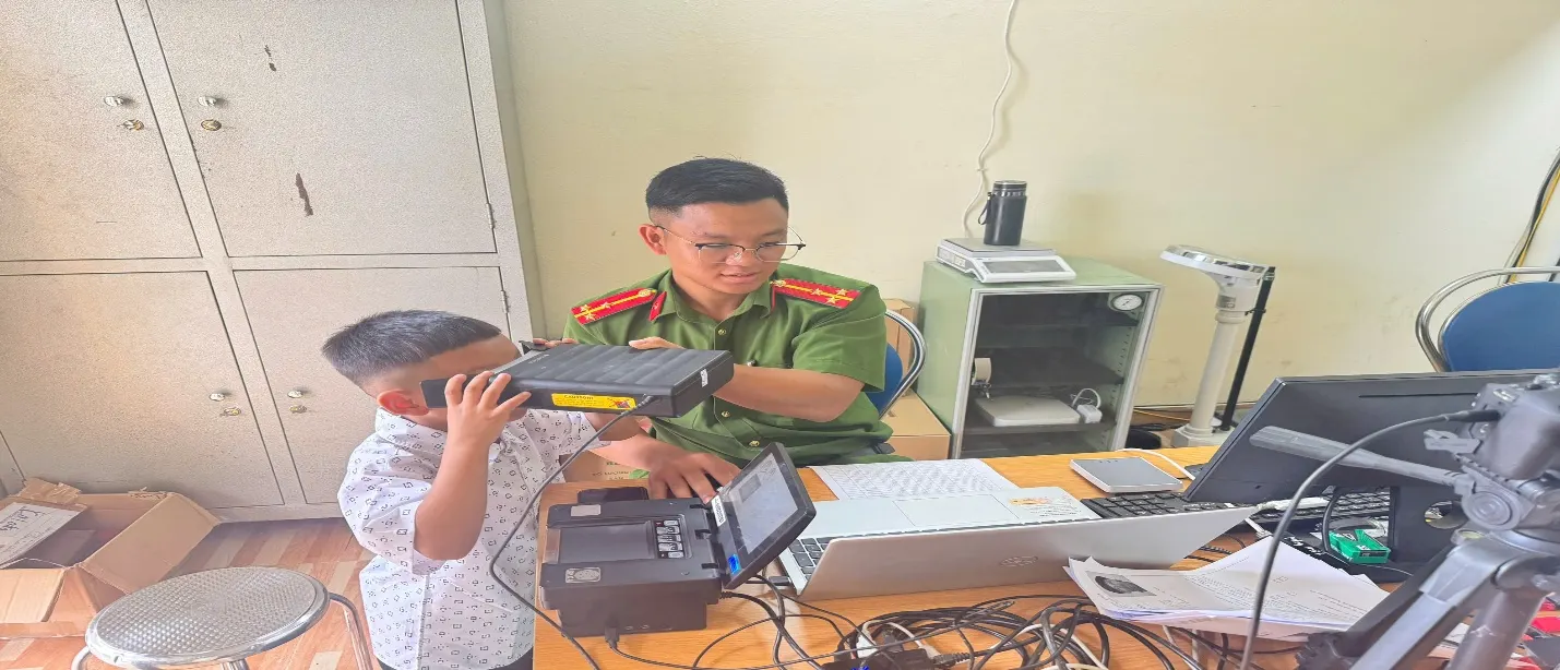 Cán bộ Công an thực hiện thu nhận dữ liệu sinh trắc học cho trẻ em dưới 14 tuổi