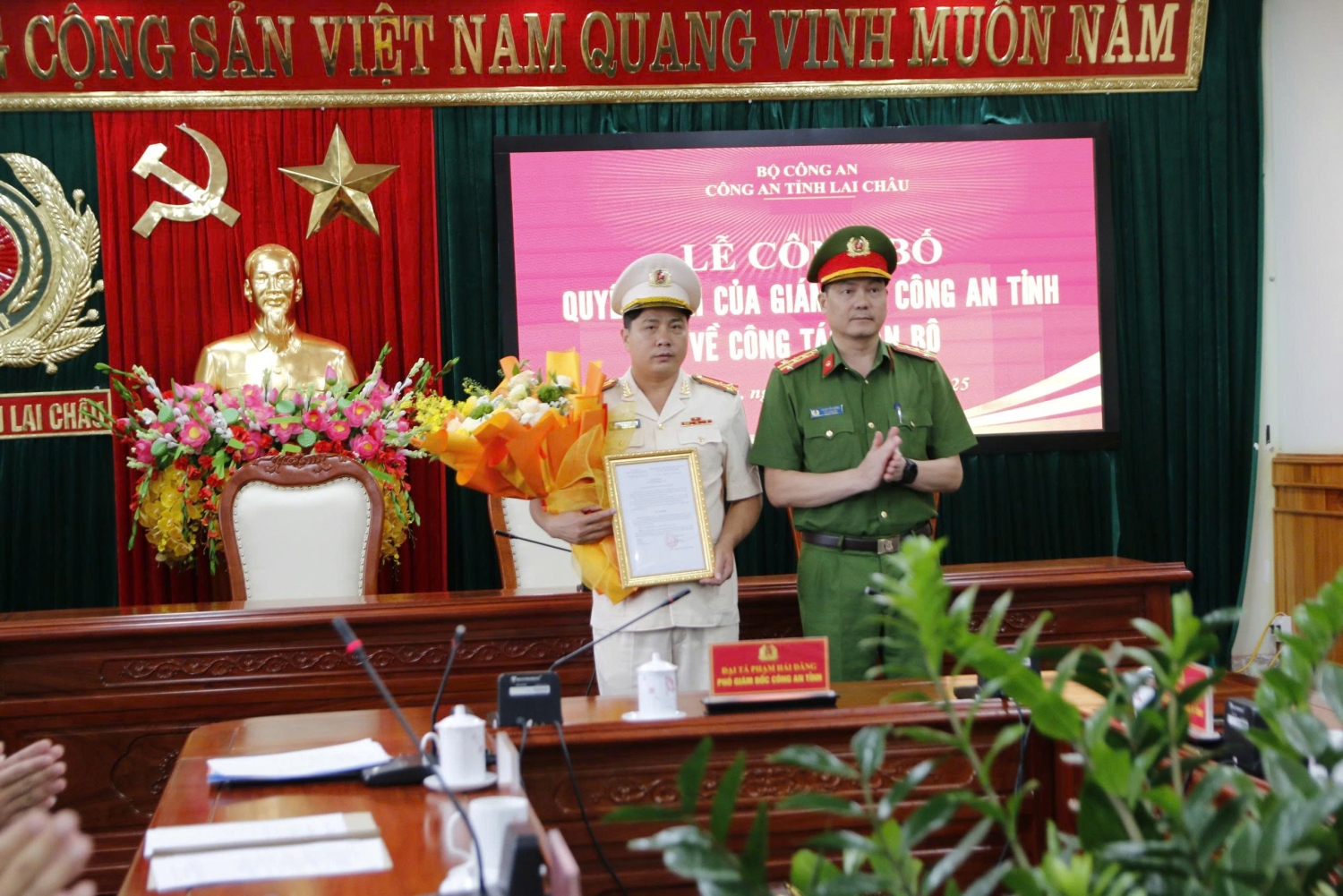 Đại tá Phạm Hải Đăng - Phó Giám đốc Công an tỉnh trao quyết định của Giám đốc Công an tỉnh, tặng hoa chúc mừng đồng chí Thượng tá Nguyễn Mỹ Đồng